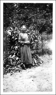 Ida Gates posing in front of tropical foliage