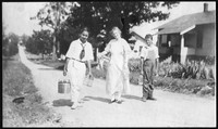 Sallie Sutherland and children with canning supplies walking along a road