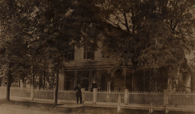 Flavius and Harriet Littlejohn standing in front of their home in Allegan, Michigan with an unknown girl