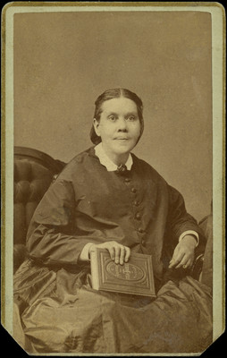 Ellen G. White posing with book "Around the Tea-Table"