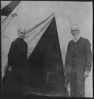 Frances and Frank Peabody in front of a camp meeting tent