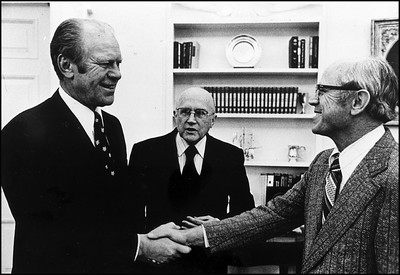 Gerald Ford shakes hands with Richard Hamill while Robert Pierson looks on