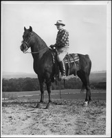 Leonard Brunie facing away from camera on horseback